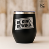 Black 12 oz stainless wine tumbler with silver laser-engraved “Be Kind. Rewind.” retro ticket design.